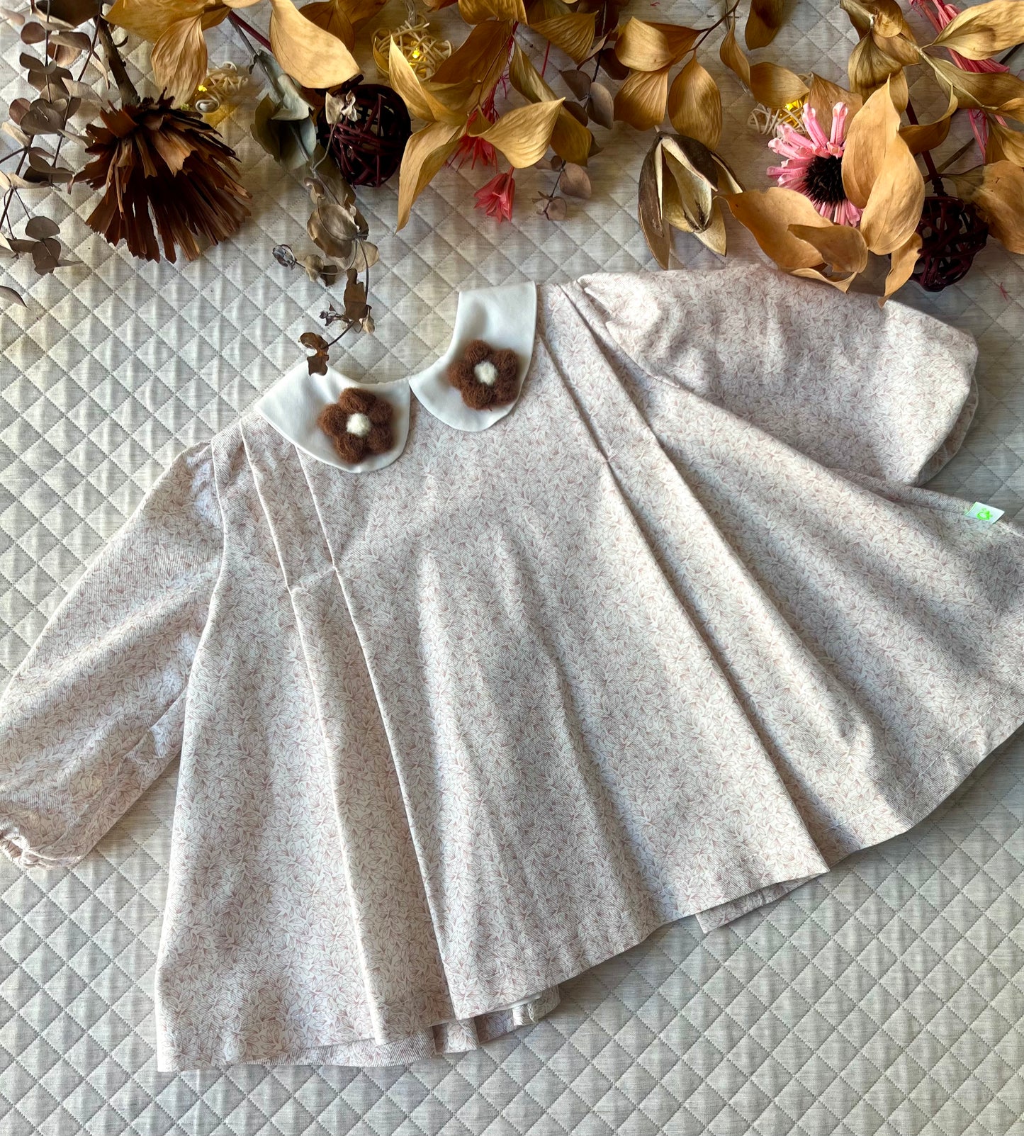 Vestito_svasato_con_pieghe_e_colletti_con_fiori_applicati_davanti